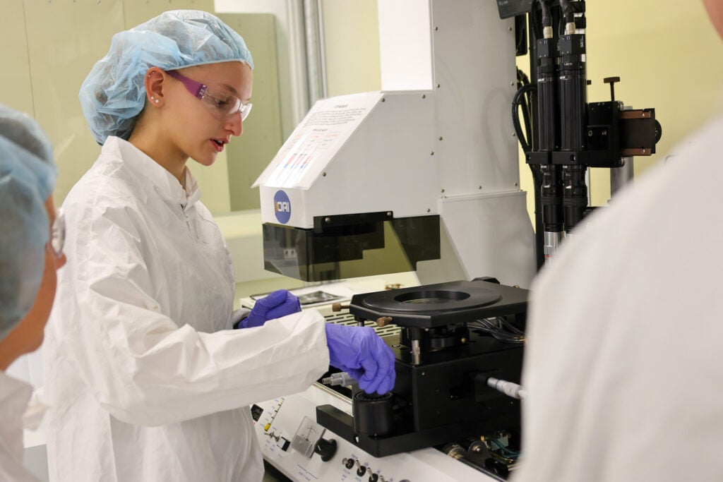 In a cleanroom environment, Alfred State College students learn to operate sensitive testing and analysis equipment