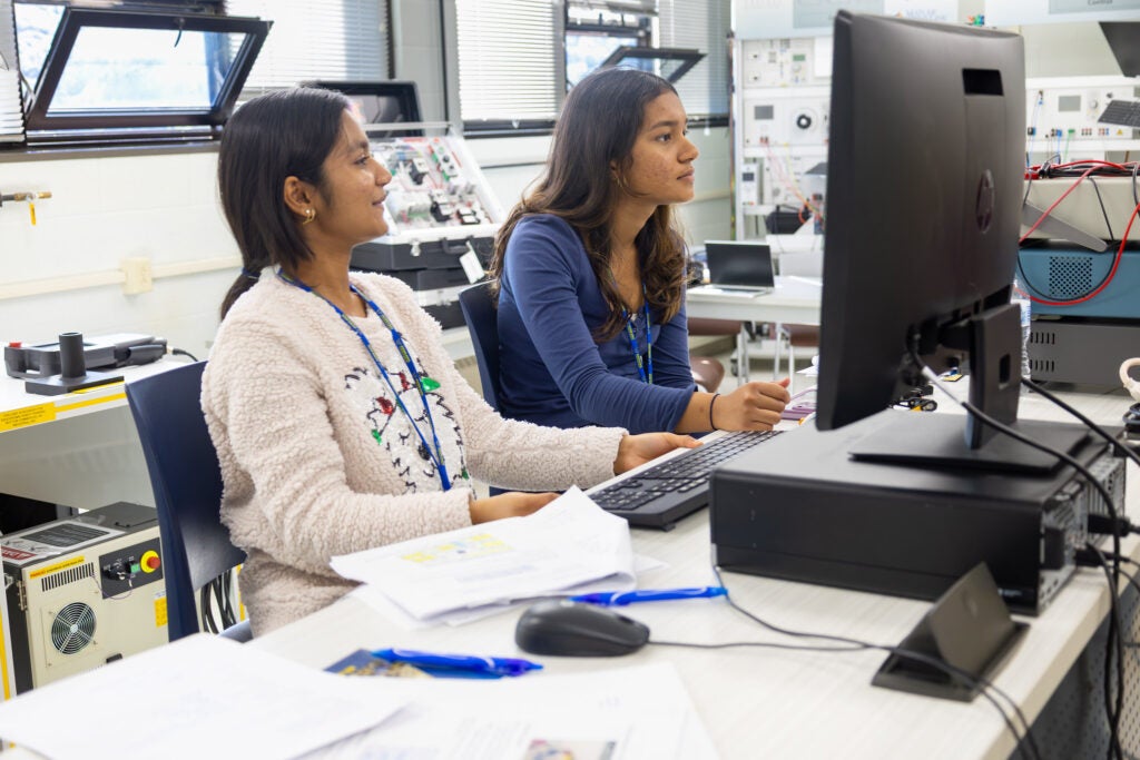 Two high school students review information on a computer screen in a lab at Alfred State College